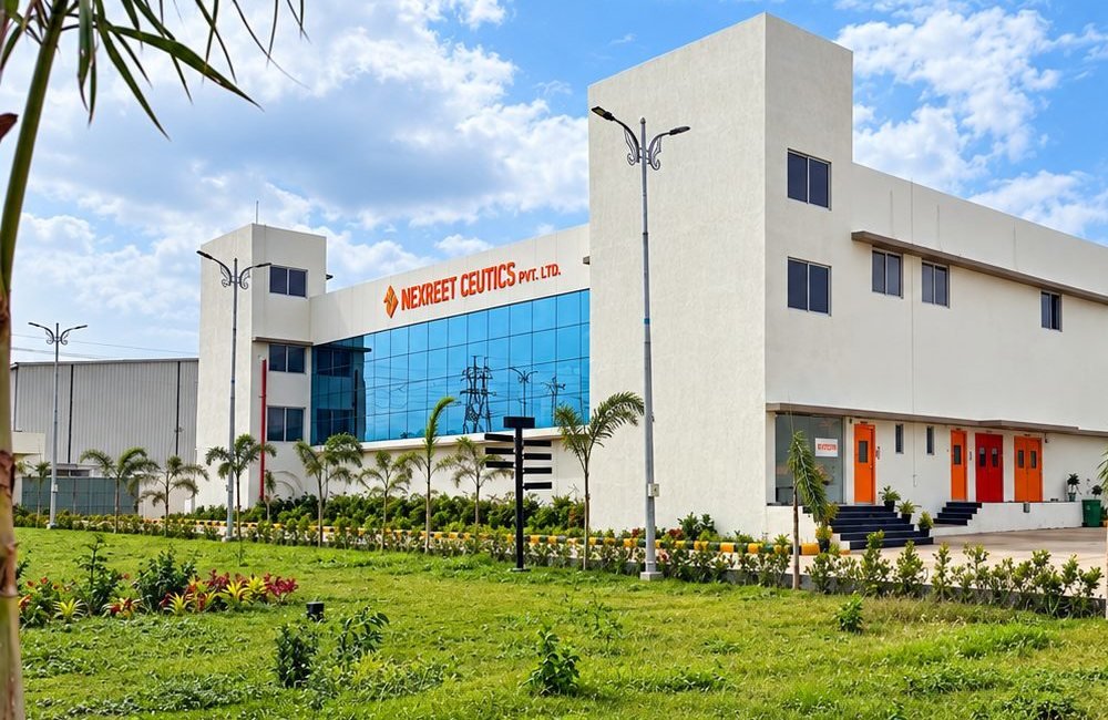 Landscaped grounds and young palms in front of the Nexreet Ceutics building